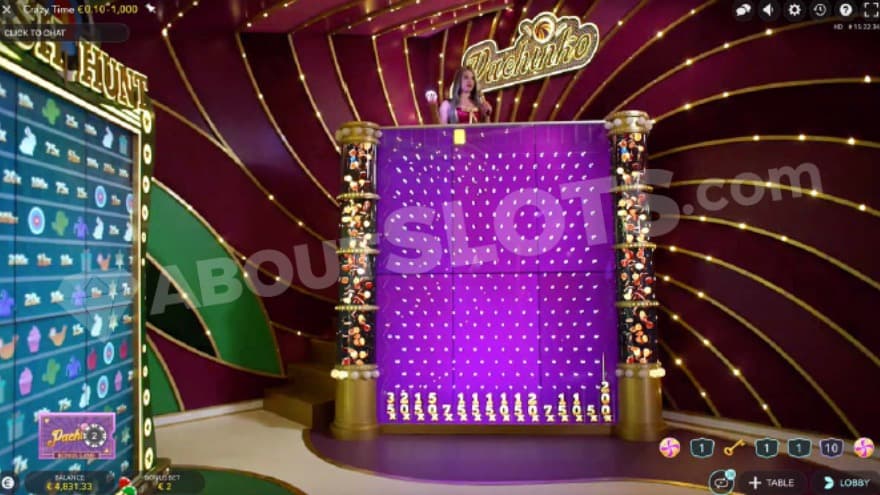 Pachinko feature being active with a big pachinko board presented with a host standing above it.