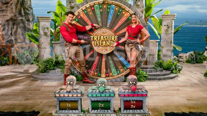 Base game showing a big wheel with a game host on standing on each side of it.