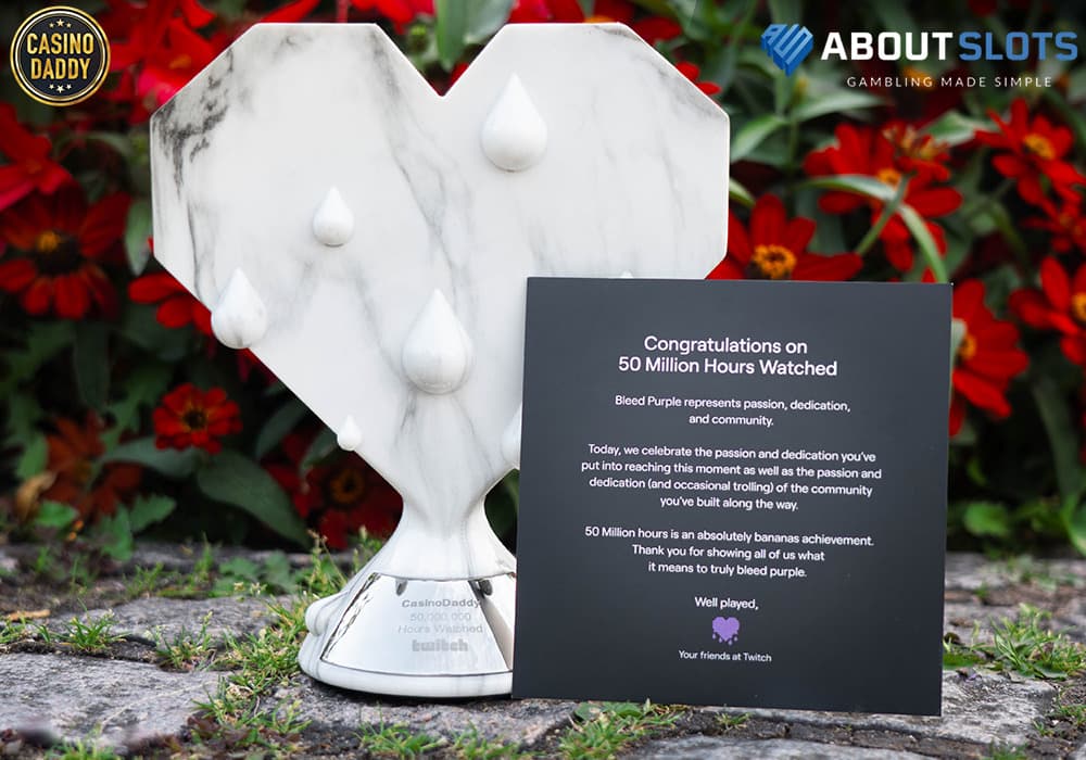 CasinoDaddy gets award for 50 millions hours viewed, with a picture showing the Bleed Purple Statue in white marble.