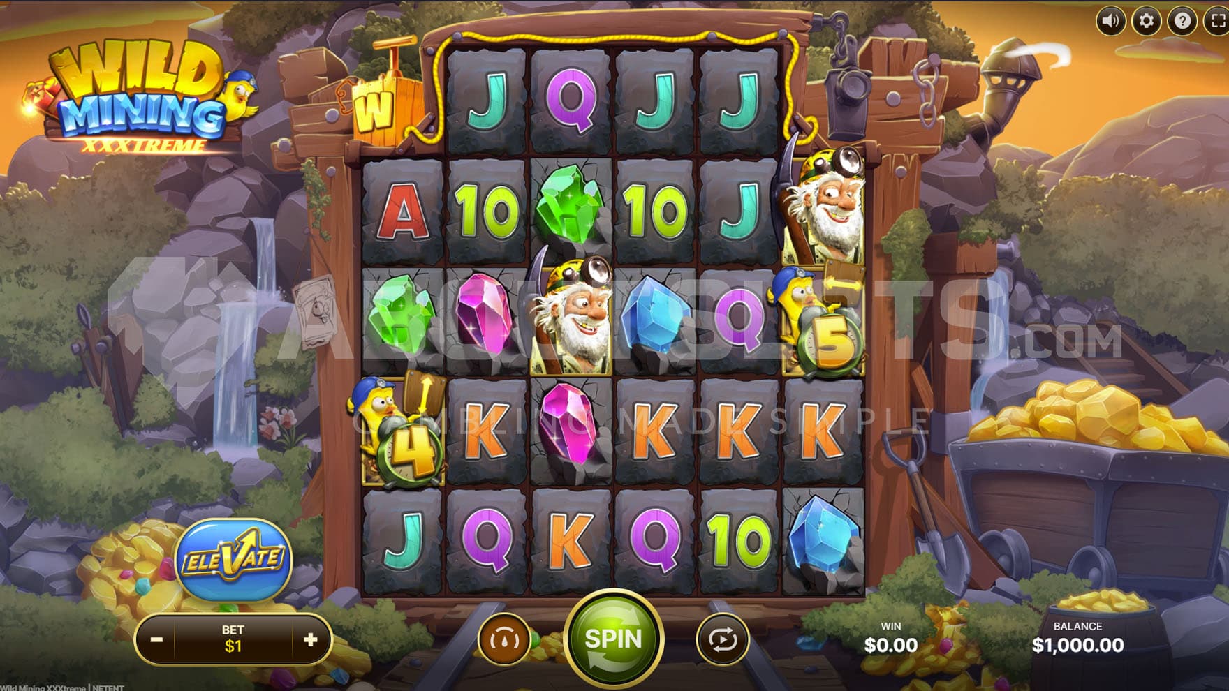 Base Game view of a 6-reel grid on a backdrop of a mine entrance with gold nuggets and gemstones scattered around.